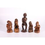 Borneo, carved male wooden figure, 20cm and four other small carvings of squatting figures with