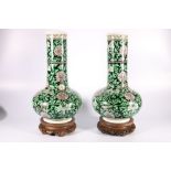 Pair of 19th Century large famille verte bottle vases with long ribbed column necks, the black