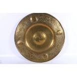 An Arts & Crafts repousse brass charger in the manner of Alexander Ritchie or Glasgow School with
