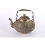 Indian white metal relief decorated tea pot with swing handle, stamped "900" to the base, 486g gross