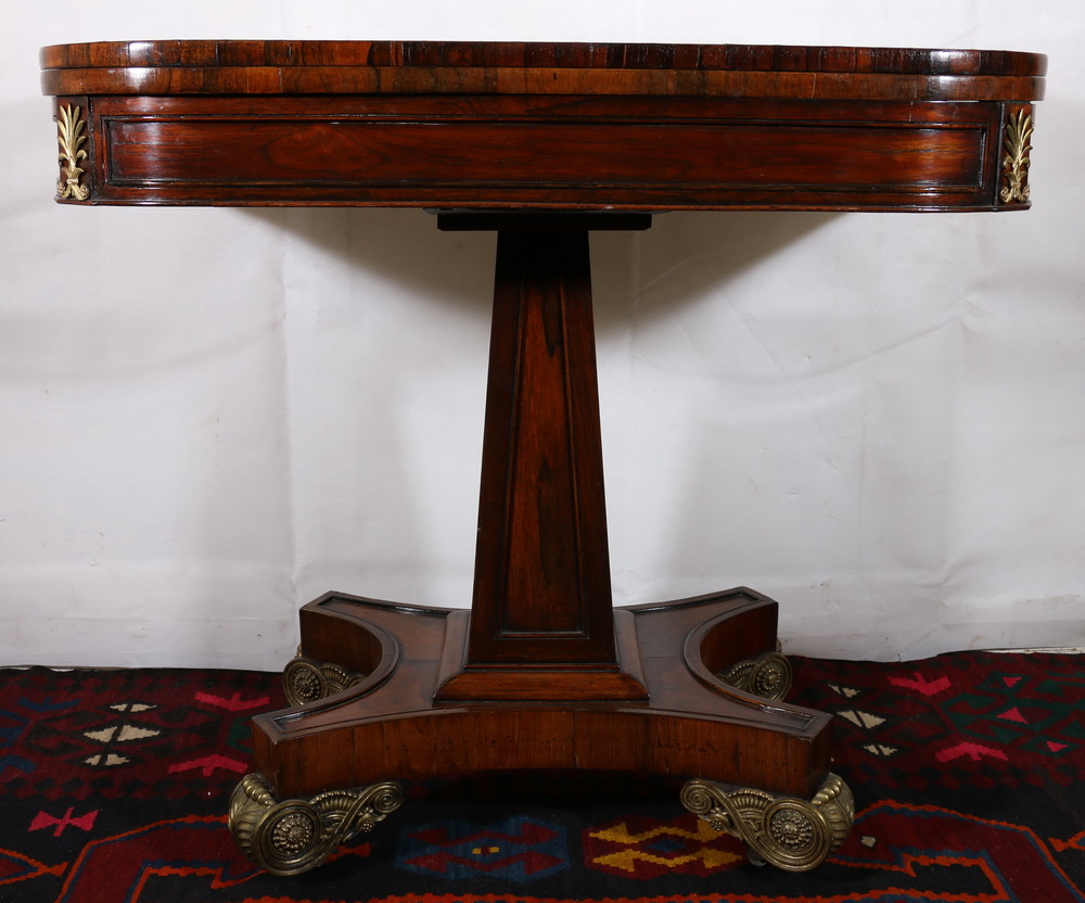 19th century rosewood and coromandel crossbanded fold over games table raised on fielded obelisk