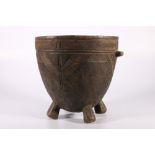 African deep wooden bowl on four supports with loop handles and incised decoration of chevrons to