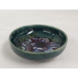 Moorcroft Pottery Anemone pattern circular footed dish with green ground. 11.5cm dia, paper label