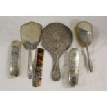 Silver backed dressing table mirror and brush; also two non matching brushes, a comb and a hand