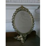 Pierced brass swing toilet mirror on foliate base.