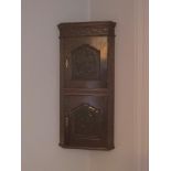 Antique two tier oak hanging corner cupboard with carved panels.