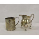 Silver cream jug raised on four pad supports also a small engraved christening mug (2)