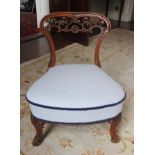 Victorian low nursing chair, pierced scrolling back, over upholstered seat on cabriole supports.