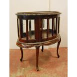 Mahogany oval display cabinet, the beaded frieze over bevelled glass panels, serpentine apron,