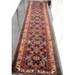 Persian runner with floral decoration over blue ground, and triple border, 414cm x 102cm.