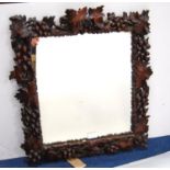 Carved fruitwood frame decorated with vines and grapes, enclosing mirrored glass plate, 53cm wide,