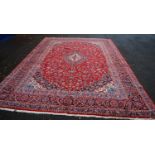 Isfahan carpet with central medallions, all over floral design, red ground, and border, 415cm x