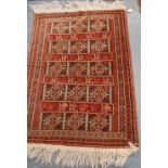 Persian rug with rosettes and cockerels over red ground, and triple border, 134cm x 95cm.