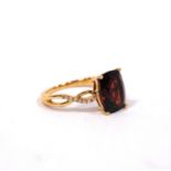 Dress ring with almandine garnet of bowed shape between diamond-set shoulders, in gold, '14k',