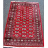 Tekke design rug with three rows of twelve guls over red ground and border, 186cm x 125cm.