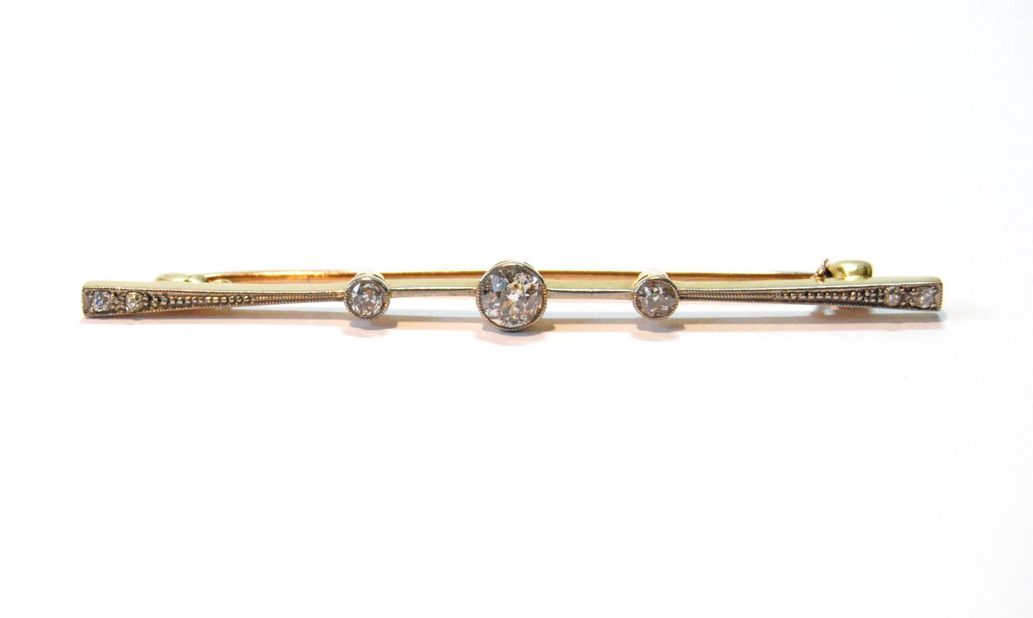 Diamond bar brooch with three millegrain-set brilliants, and two others, smaller, at each end,