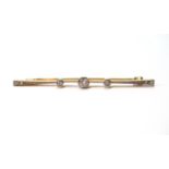 Diamond bar brooch with three millegrain-set brilliants, and two others, smaller, at each end,