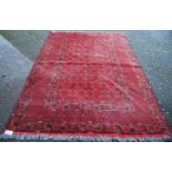 Afghan carpet with central panel decorated with rosettes, multiple border over red ground, 288cm x