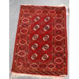 Afghan rug with two rows of five guls over red ground, and triple border, 118cm x 80cm.