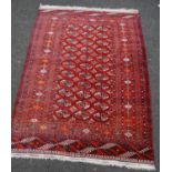 Tekke design rug with three rows of eleven guls over red ground, multiple border, 200cm x 132cm.