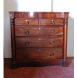 Victorian mahogany column chest with serpentine top over concealed frieze drawer, two short and