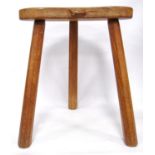 Oak milking stool by Robert 'Mouseman' Thompson, the shaped seat carved with a mouse, on splayed