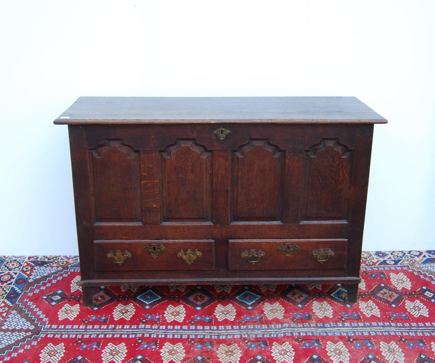 19th century oak coffer with moulded rectangular top over arched panels, two short drawers, raised