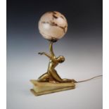 An Art Deco figural desk lamp, the gilt metal lamp modelled as a 1930's dancer, with arms aloft,