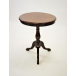 A George III style mahogany tripod table, the circular cross banded top raised upon a baluster