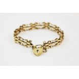 A 9ct gold gatelink bracelet, London 1977, with attached 9ct gold padlock clasp and safety chain,