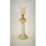 An alabaster urn on pedestal, the campana shaped urn raised upon a spirally lobed pedestal, circular