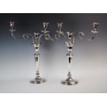 A pair of early 20th century silver plated three branch candelabras, each with two stylised