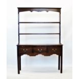 An 18th century style oak dresser, 20th century, with an open plate rack above a rectangular moulded