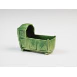 A green glazed pottery cradle, 18th century, Elliot Pottery, designed on two rocker supports,