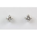 A pair of diamond solitaire stud earrings, each set with a brilliant cut diamond measuring approx