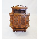 A late 19th century golden oak wall cabinet, the twin swan neck pediment above a panel centred