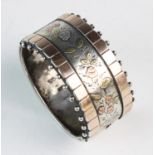 A Victorian silver hinged bangle, marks for Birmingham, 1882, the front section decorated with a