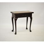 A George III mahogany tea table, the rectangular folding top above a single frieze drawer, raised