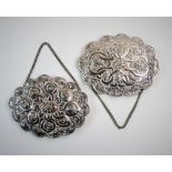 A near pair of Turkish white metal mounted mirrors, each of oval form, with scalloped rim and