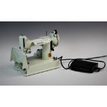 A 1960s white model Singer Featherweight 221K sewing machine in original case with instruction