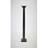 A 19th century mahogany torchere, the circular top upon a fluted Doric column and a square plinth