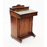 A late Victorian walnut davenport, of small proportions, the inlaid hinged cover enclosing a