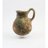 A Cypriot Bronze Age jug, circa 1850 - 1600 BC, of bulbous form with attached handle from shoulder