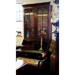 An early 19th century mahogany bureau bookcase, with a moulded tapering cornice above a pair of