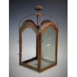 A 19th century hanging metal lantern, with four arched glass panels within a painted metal frame,