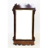 A George III mahogany mirror, with a gilt border fretwork frame, bevelled mirror plate, 103cm x 57cm