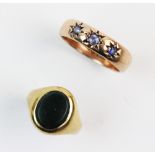 A 9ct gold sapphire set gypsy style ring, comprising three old cut sapphires claw set to a rose gold