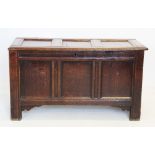 An early 18th century oak coffer, the hinged lid with three invert moulded panels above three