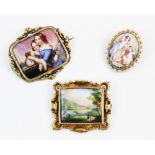 A Victorian hand-painted porcelain brooch, depicting an outdoor scene with a lake and figures in the