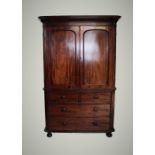 A Victorian mahogany linen press, with a cavetto cornice above two panelled doors enclosing four